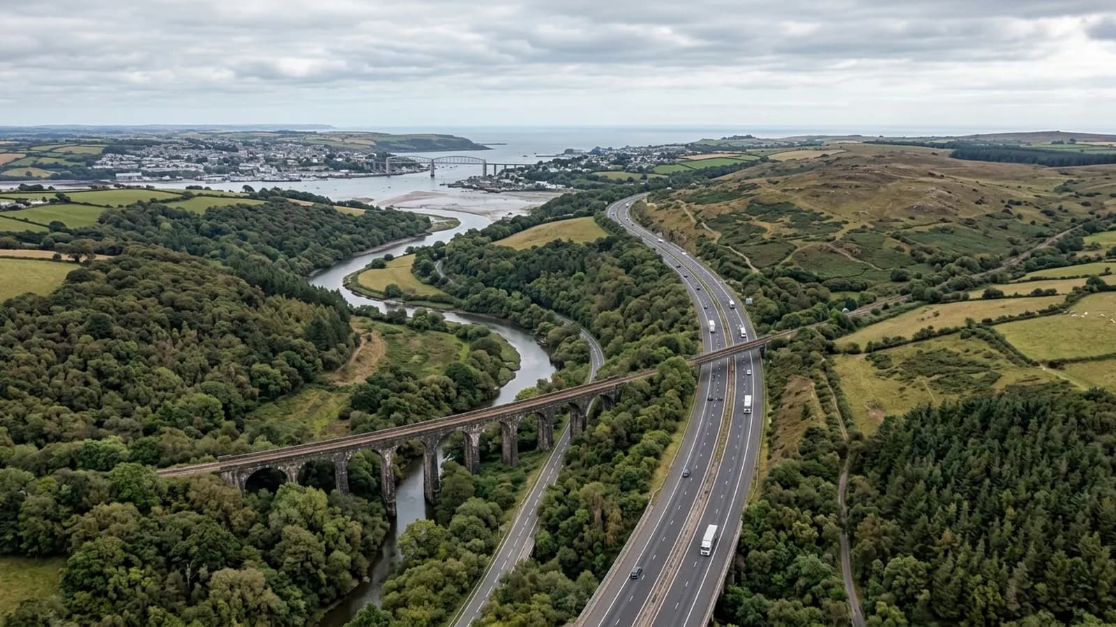 A dual carriageway running south west along the edge of Dartmoor, crossing a wooded valley on a stone viaduct